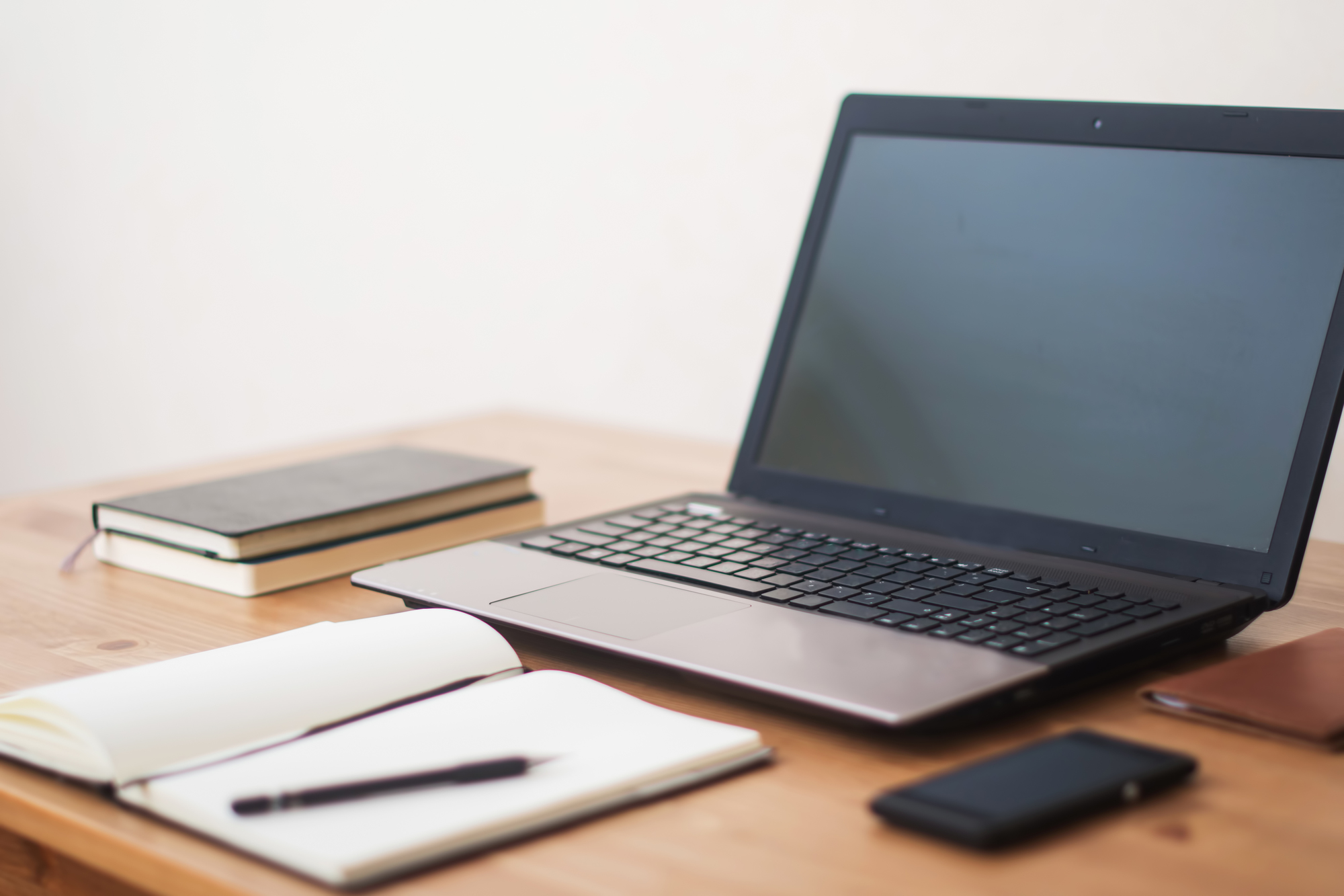 Office workplace with laptop, smart phone and notebook on wood table